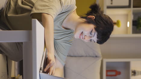 Vertical-video-of-Happy-young-woman-using-laptop-at-night.